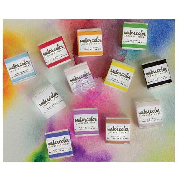 Assorted Prima Watercolor Confections pan sets displayed on a colorful watercolor background.