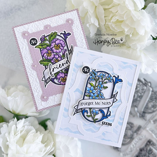 Two handmade Spring Seeds cards with purple pansies and blue forget-me-nots.