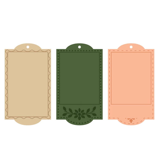 Three decorative paper label templates with scalloped edges and pre-punched holes, shown side by side on a plain white background. The labels come in peach, dark green with a floral motif, and beige with a scalloped border.